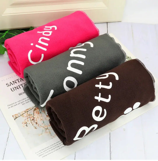 Personalized dog blanket in three colors, pink, gray, and brown, with custom pet names like Cindy, Ronny, and Betty printed in large white letters.
